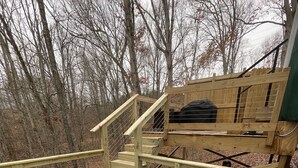 Ein Whirlpool auf einer Holzterrasse mit einer Holztreppe und einer Bank im Hintergrund.
