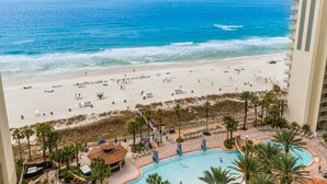 A beach view from a hotel balcony with a pool and lounge area. - Oceanfront, Swimming Pool, 14th Floor Condo (Panama City Beach)