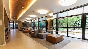A spacious lobby with modern seating, large windows, and a wooden ceiling.