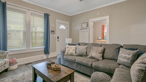 A living room with a grey sofa, a wooden coffee table, and a patterned rug. - Your Newest, Remodeled, and Fully-Furnished AirB&B in the Heart of Fayetteville! (Fayetteville)