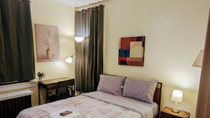 Ein ordentlich eingerichtetes Schlafzimmer mit einem Bett, einem Schreibtisch und einem Stuhl.
