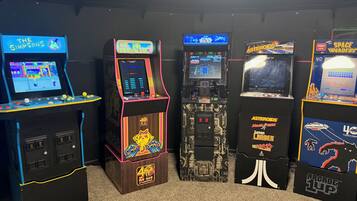 Una hilera de máquinas de arcade con varios juegos, incluyendo 'The Simpsons' y 'Star Wars'.