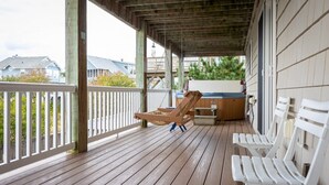 A wooden deck with white railings, a wooden chair, and a white bench. - 3min Walk to Beach, Pool, Hot Tub, & Game Room! (Corolla)
