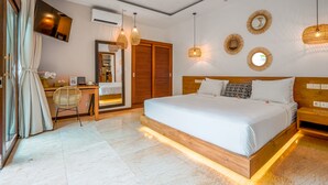 A modern hotel room with a large bed, a desk, a chair, and a TV. - Frangipani Villa Kuning At Berawa (Canggu)