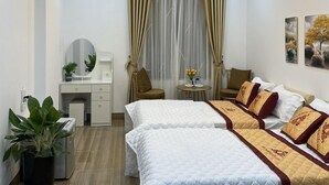 A hotel room with two beds, a desk, a chair, a small table, and a potted plant. - Huyen Anh Hotel (Hanoi)