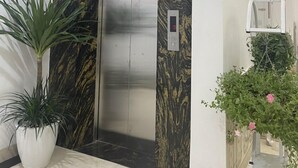 An elevator with a marble wall and a digital display. - Huyen Anh Hotel (Hanoi)