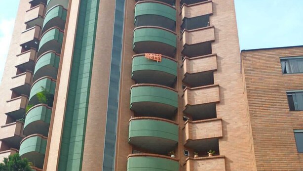 A high-rise building with multiple balconies, a brick facade, and a tiled entrance area. - Edificio san thelmo laureles  (Medellín)