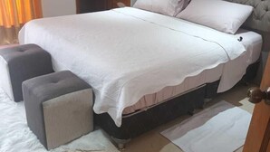A bedroom with a bed, a nightstand, a chair, and a door. - Edificio san thelmo laureles  (Medellín)