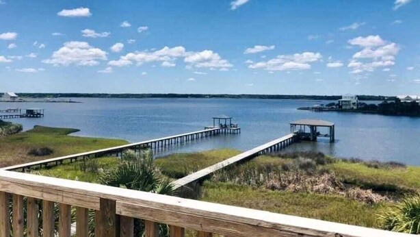A view of a lake with wooden docks and a gazebo. - “Coastal Haven” Gorgeous 6 bedroom home pool (North Topsail Beach)