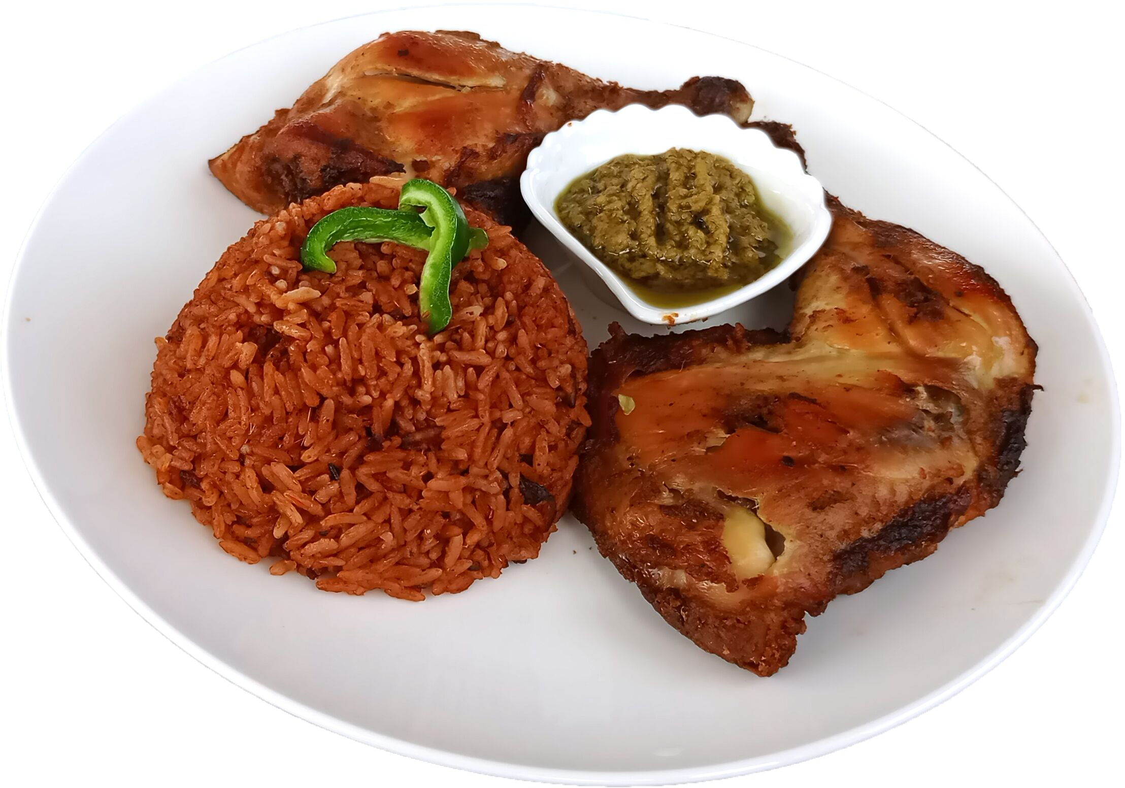 A plate with red rice, grilled chicken, and a small bowl of green sauce.