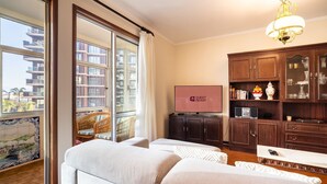 A hotel room with a balcony, a television, a minibar, and a dining area. - GuestReady - Varanda de belas lembranças (Funchal)