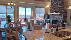 A spacious kitchen with granite countertops, a built-in dishwasher, and a stone fireplace. - New! Peaceful Mountain Views, Deck, Trails nearby, Pool Table. (Mars Hill)