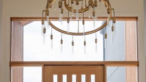 A wooden door with vertical slats, a potted plant, and a hanging light fixture.