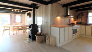Une cuisine moderne dotée d’un îlot central, d’un plancher en bois et d’un coin repas avec une table et des chaises.