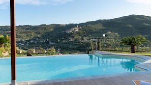 Una piscina con vistas a un pueblo en la ladera.