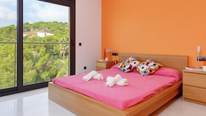 Ein modernes Schlafzimmer mit einem großen Fenster, einem hölzernen Bett und einer orangefarbenen Wand.