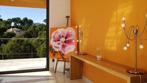 Ein modernes Zimmer mit großem Fenster, einem Blumenbild und einer Stehlampe.