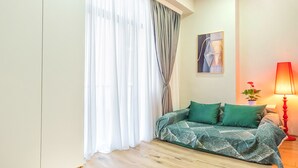 A room with a sofa, a lamp, and a painting on the wall. - H&B apartments Akhmeta (Tbilisi)