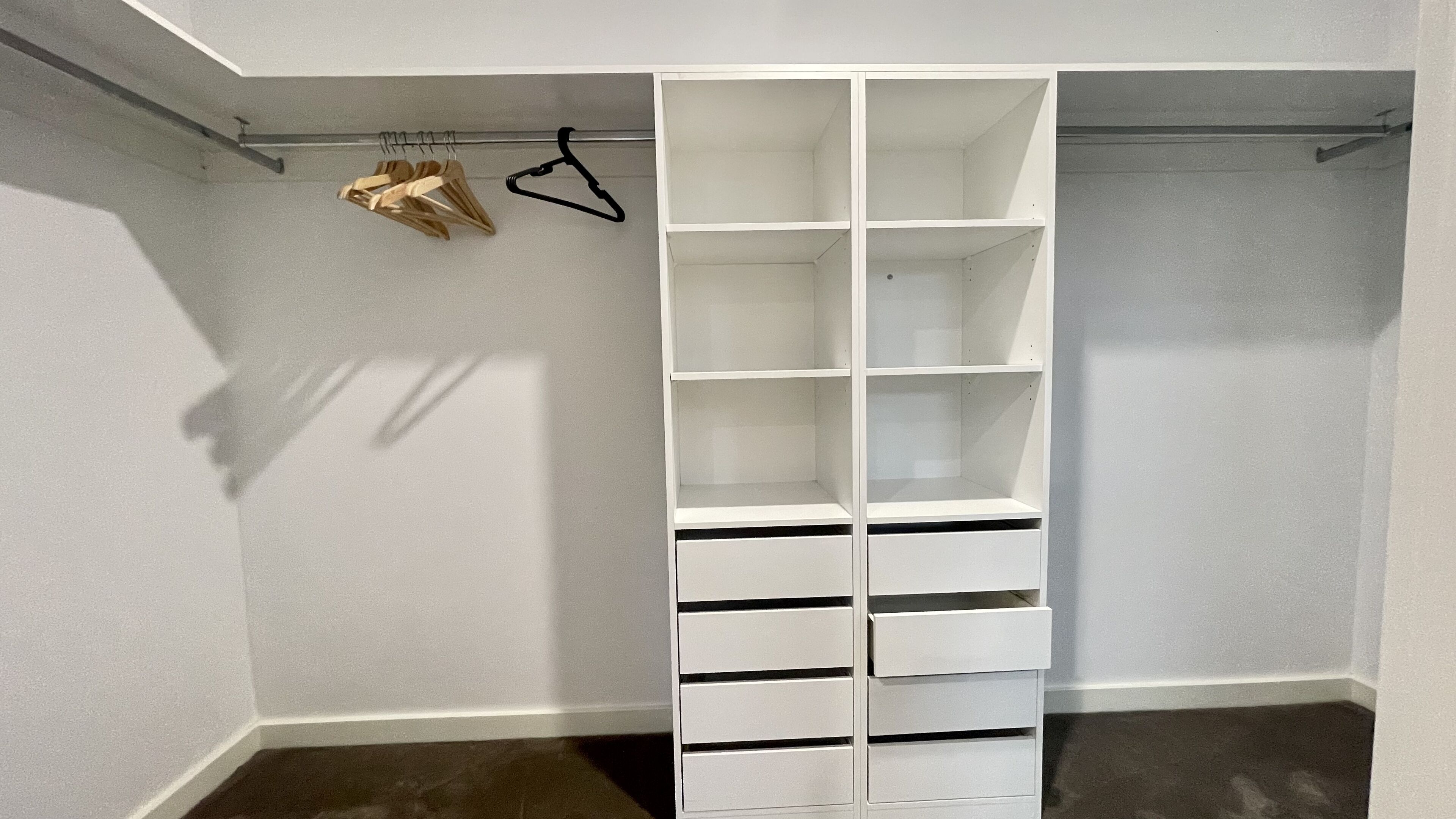 A walk-in closet with multiple shelves and hanging space.