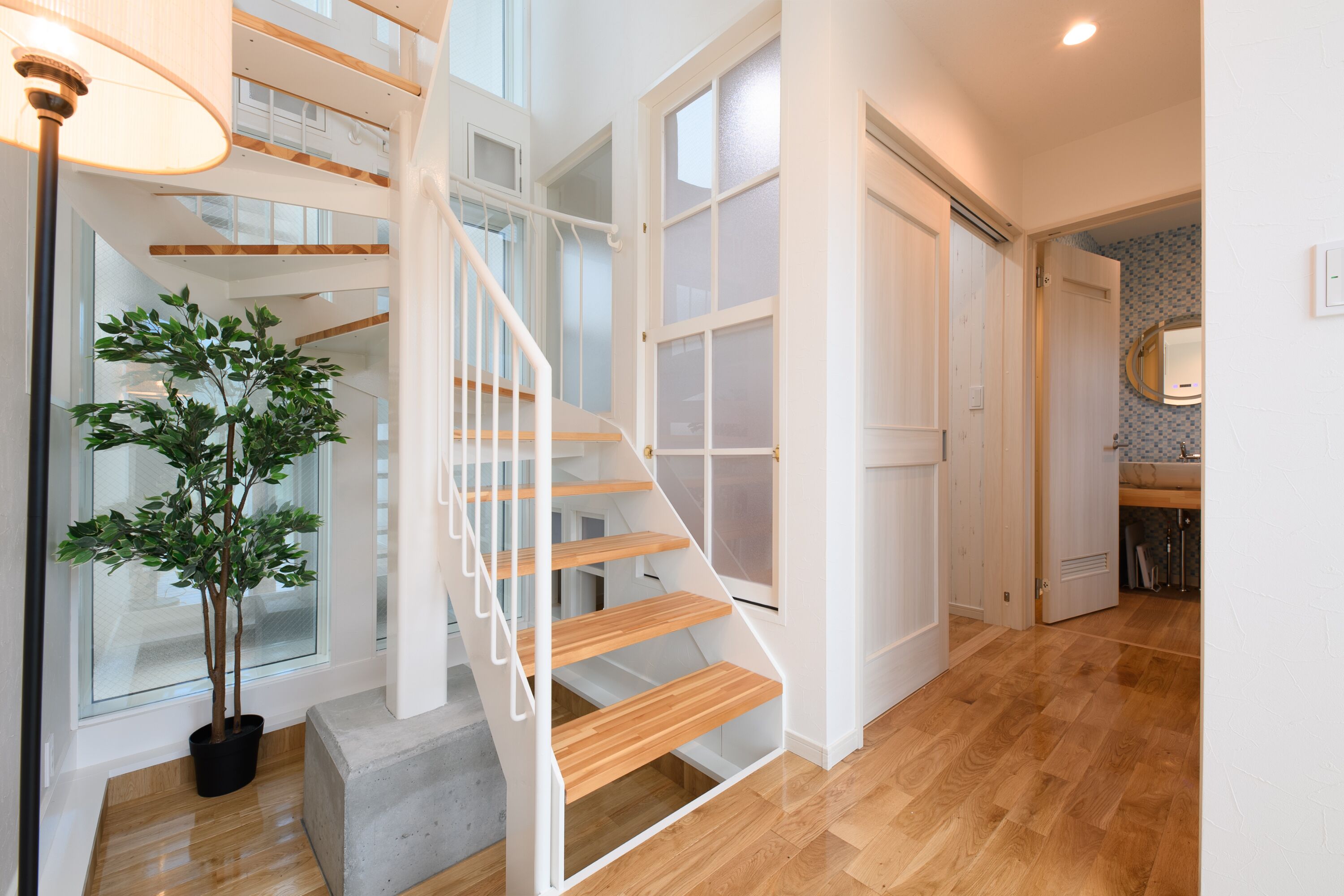 A staircase with wooden steps and white railings, leading to a second floor.