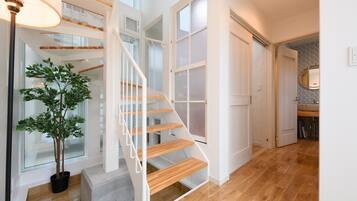 A staircase with wooden steps and white railings, leading to a second floor.