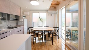 Une cuisine moderne dotée d’un îlot central, d’appareils électroménagers intégrés et de grandes fenêtres.