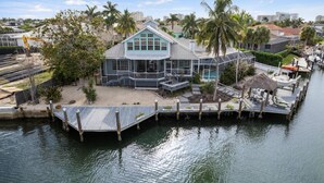 Une propriété située au bord de l’eau, comprenant une grande maison, un quai et un bateau.