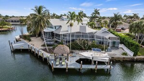 Une propriété située au bord de l’eau, comprenant une grande maison, un quai et un bateau.