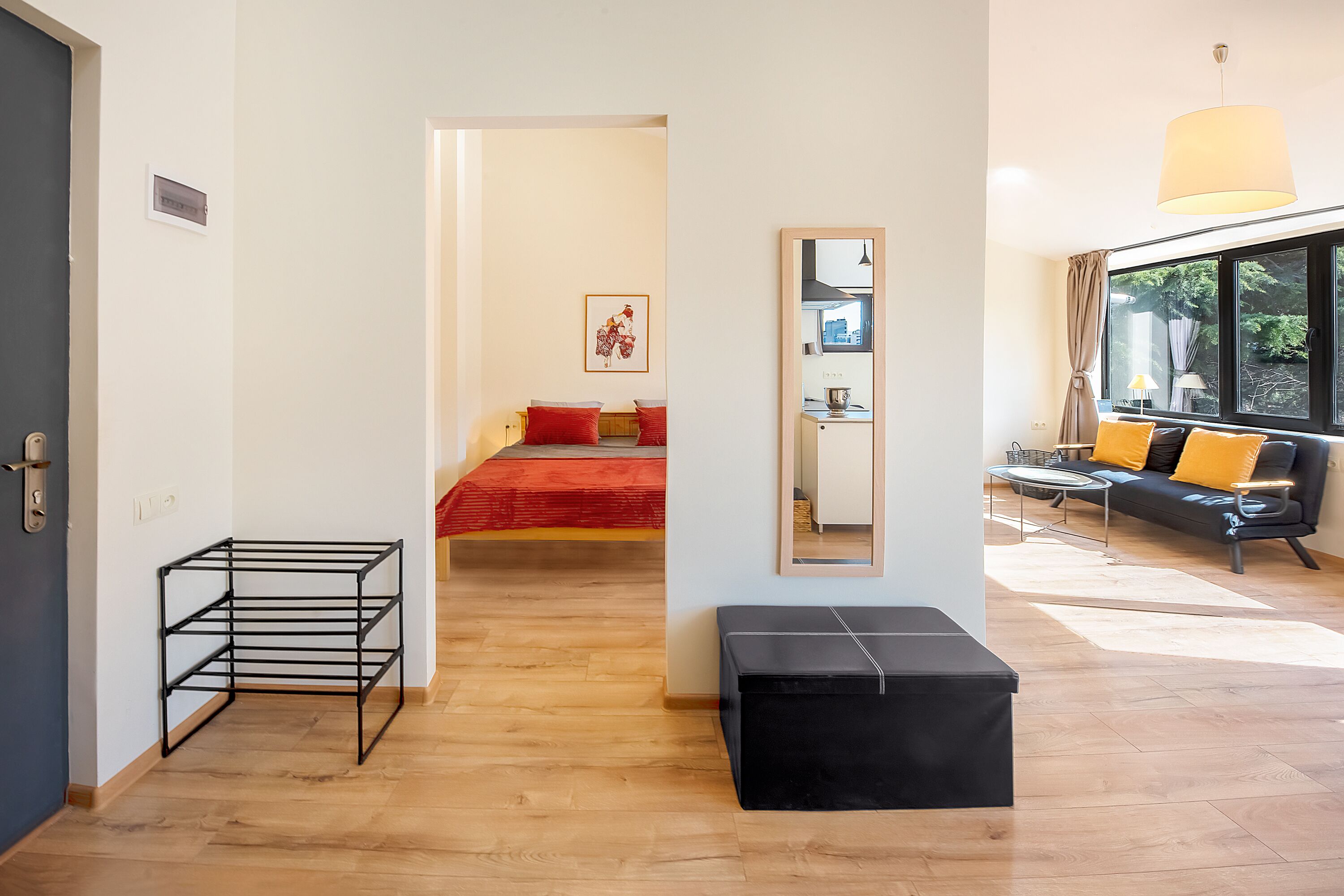 Uma sala moderna com um sofá, uma mesa de centro e uma janela ampla.