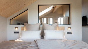 A bedroom with a large bed, two bedside tables, a mirror, and a TV. - Ferienwohnung 2, 48qm (Eggstätt)