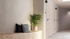 A hallway with a wooden bench, a potted plant, and wooden doors. - Ferienwohnung 2, 48qm (Eggstätt)