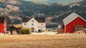 A rural landscape with a white house, a red barn, and a red house. - 4 bedroom cozy home in Svorkmo (Svorkmo)