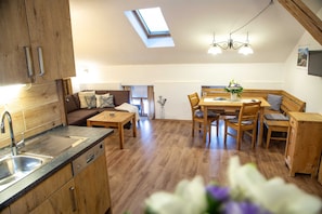 A modern kitchen with a skylight, wooden cabinets, and a built-in dishwasher.