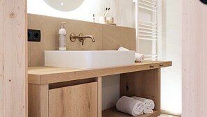 A modern bathroom with a wooden vanity, a large mirror, and a towel rack. - Ferienwohnung 5, 60qm (Eggstätt)