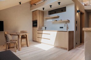 A compact kitchen with wooden cabinets, a built-in oven, and a countertop with a sink.