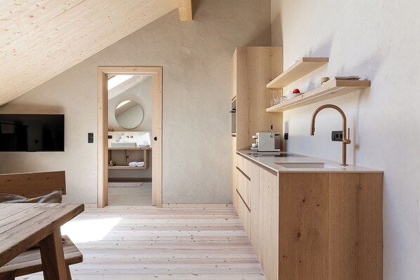 A modern kitchen with wooden cabinetry, a built-in sink, and a hanging faucet.