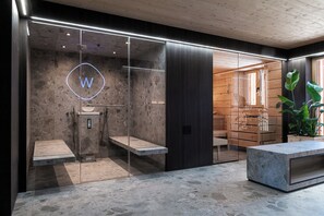 A modern interior with a reception desk, a glass enclosure with a logo, and a wooden interior.