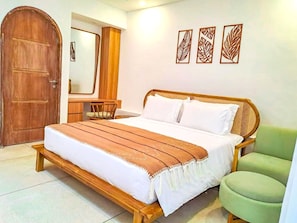 Une chambre à coucher avec un lit en bois, une chaise verte, une armoire en bois et un miroir.