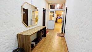A hallway with a wooden bench, a mirror, and a tiled floor. - Hostel Nepal Pvt. Ltd. (Pokhara)