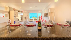 Un comedor moderno con encimera de granito, copas de vino y una botella de champán.
