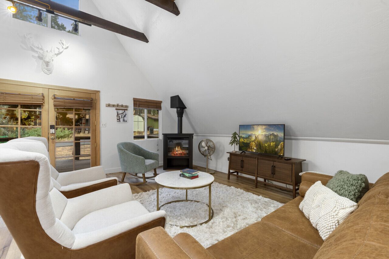 Una sala de estar acogedora con chimenea, asientos cómodos y vistas al exterior.