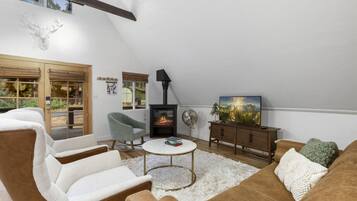 Una sala de estar acogedora con chimenea, asientos cómodos y vistas al exterior.