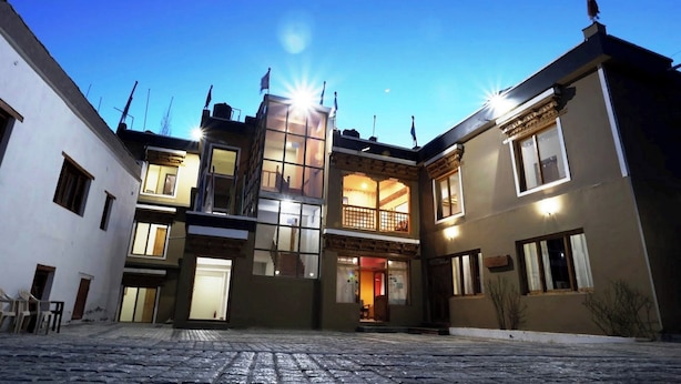 Um edifício com pátio central, várias varandas e uma mistura de estilos arquitetônicos modernos e tradicionais.