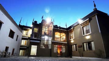 Un edificio con patio central, varios balcones y una mezcla de estilos arquitectónicos modernos y tradicionales.