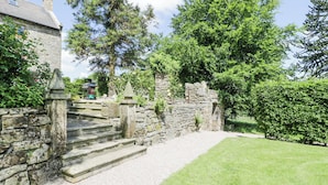 A stone staircase leading to a stone wall with a grassy area in front. - Pentre Hall (Oswestry)