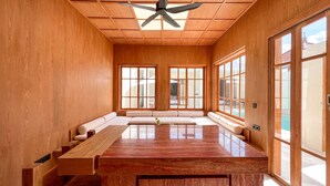 A spacious room with a large wooden ceiling, a ceiling fan, and a long wooden table. - Tekko Villa Pererenan (Canggu)