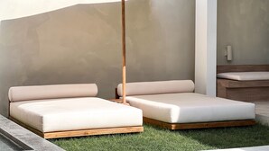 A modern outdoor seating area with two cushioned benches and a floor lamp. - Tekko Villa Pererenan (Canggu)