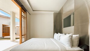 A modern bedroom with a large bed, a wooden nightstand, and a TV mounted on the wall. - Tekko Villa Pererenan (Canggu)