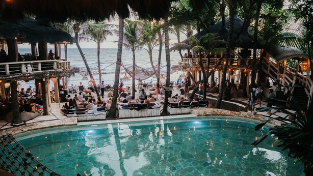 A pool area with a clear view of the ocean, surrounded by palm trees and wooden structures. - Private Pool • Hot Tub • Near Batu Bolong Beach (Canggu)