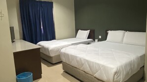 Een hotelkamer met twee eenpersoonsbedden, een bureau, een stoel, een blauwe prullenbak en een airconditioning.